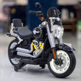 Black and silver Harley Davidson motorcycle on a reflective surface with a blurred indoor background